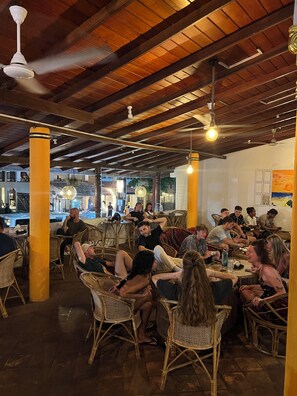 A restaurant with wicker furniture, wooden beams, and hanging light fixtures. - Hummus Hotel Hikkaduwa  (Hikkaduwa)