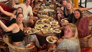 A group of people seated around a large round table in a room with wooden beams and a large window. - Hummus Hotel Hikkaduwa  (Hikkaduwa)