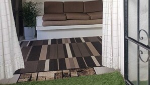 Ein Wohnzimmer mit einer Couch, einem gerahmten Kunstwerk und einem gemusterten Teppich.