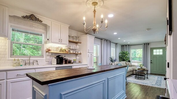 A spacious kitchen with a central island, white cabinetry, and a chandelier. - King Branch Rd · 3BR | Hot Tub | Dog Friendly | Wi-Fi | Games (Sevierville)