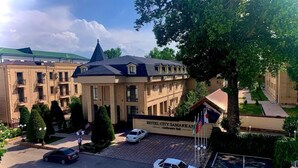 Un hotel con un amplio salón de conferencias, varios espacios de estacionamiento y un jardín bien cuidado.