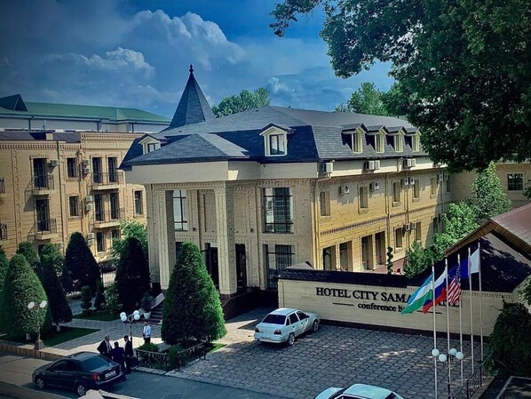 Ein Hotel mit einem markanten Turm, zahlreichen Fenstern und einem Schild, das auf die Durchführung von Konferenzen hinweist.