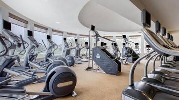 A gym with multiple treadmills, ellipticals, and weight machines.