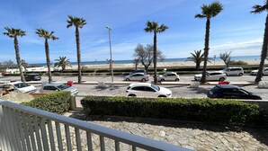 Ein Parkplatz mit mehreren Autos, Palmen und einem Strand im Hintergrund.