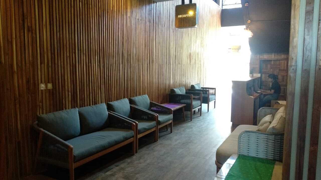 A reception area with a wooden wall, a reception desk, and seating arrangements including sofas and chairs.