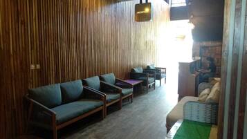 A reception area with a wooden wall, a reception desk, and seating arrangements including sofas and chairs.