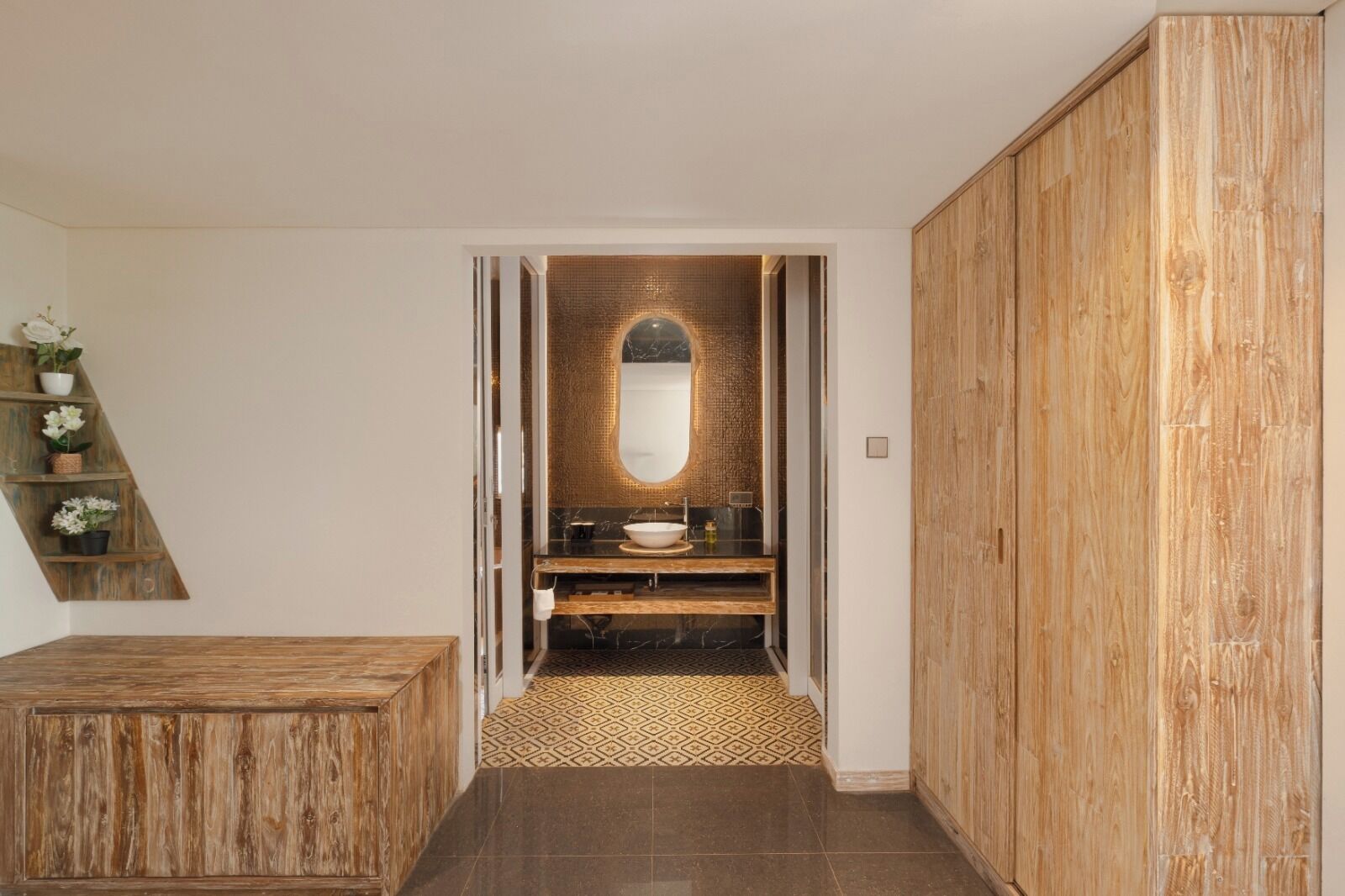 A bathroom with a wooden vanity, a large mirror, and a patterned floor.