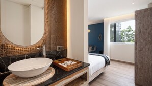 Un baño moderno con un espejo grande, un lavabo blanco y un mueble de tocador de madera.