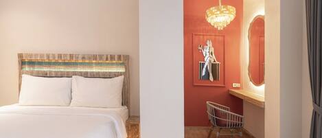 A bedroom with a wooden headboard, a bed with white bedding, a nightstand, a chair, a mirror, and a chandelier.
