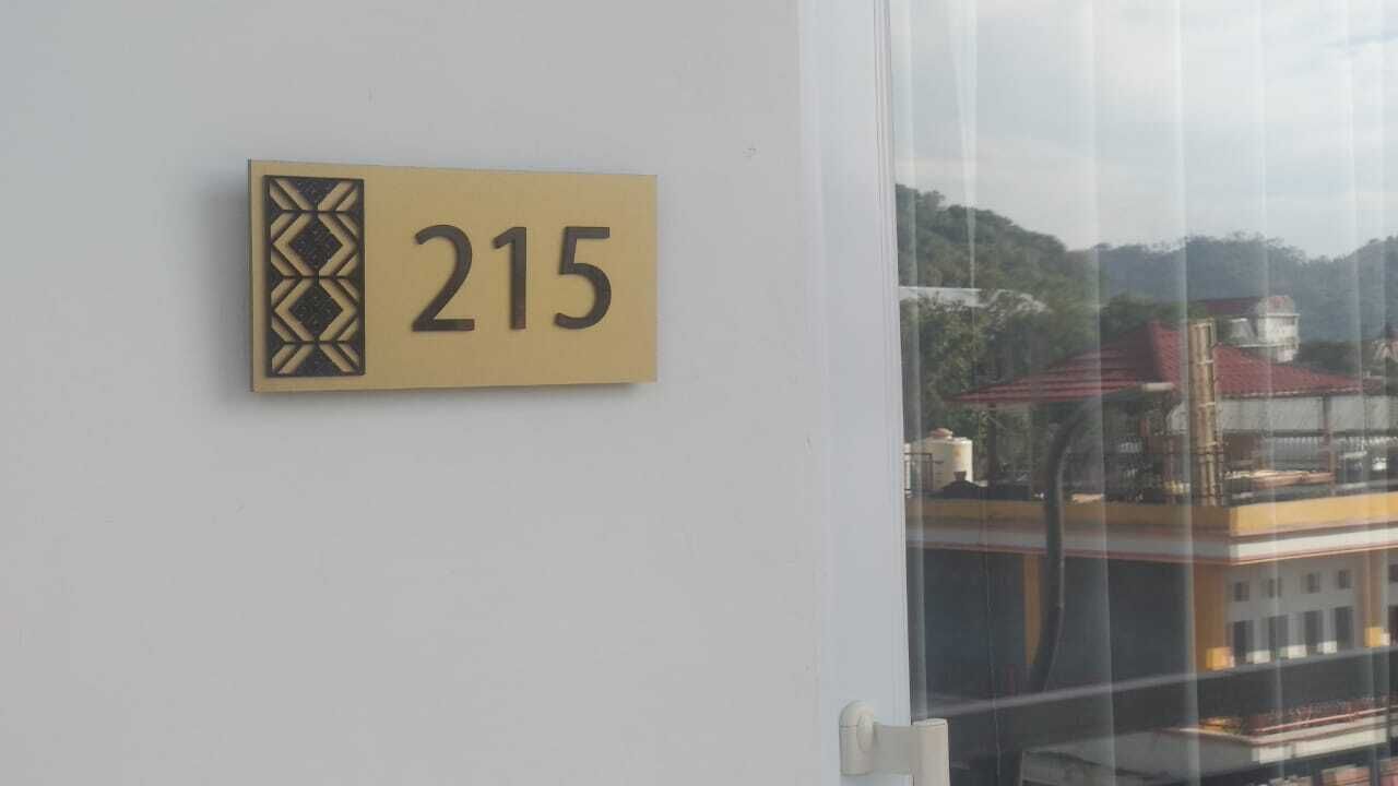 A room number sign, 215, on a white wall.