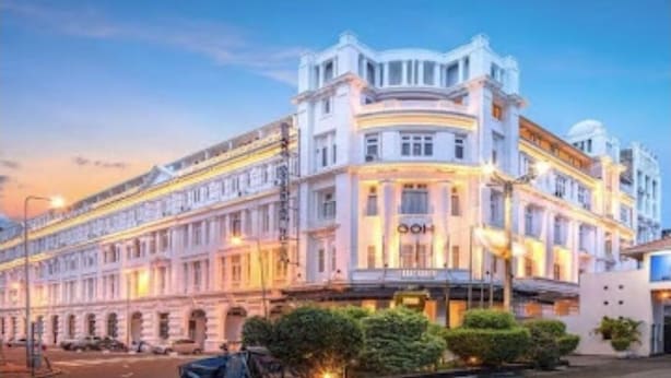 A large, historic building with a prominent 'OOH' sign, likely a hotel, featuring classical architecture with multiple stories and a central dome. - Grand Oriental Hotel (Colombo)