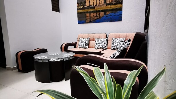 Una sala de estar moderna con un sofá, una mesa de centro y un cuadro de un paisaje montañoso.
