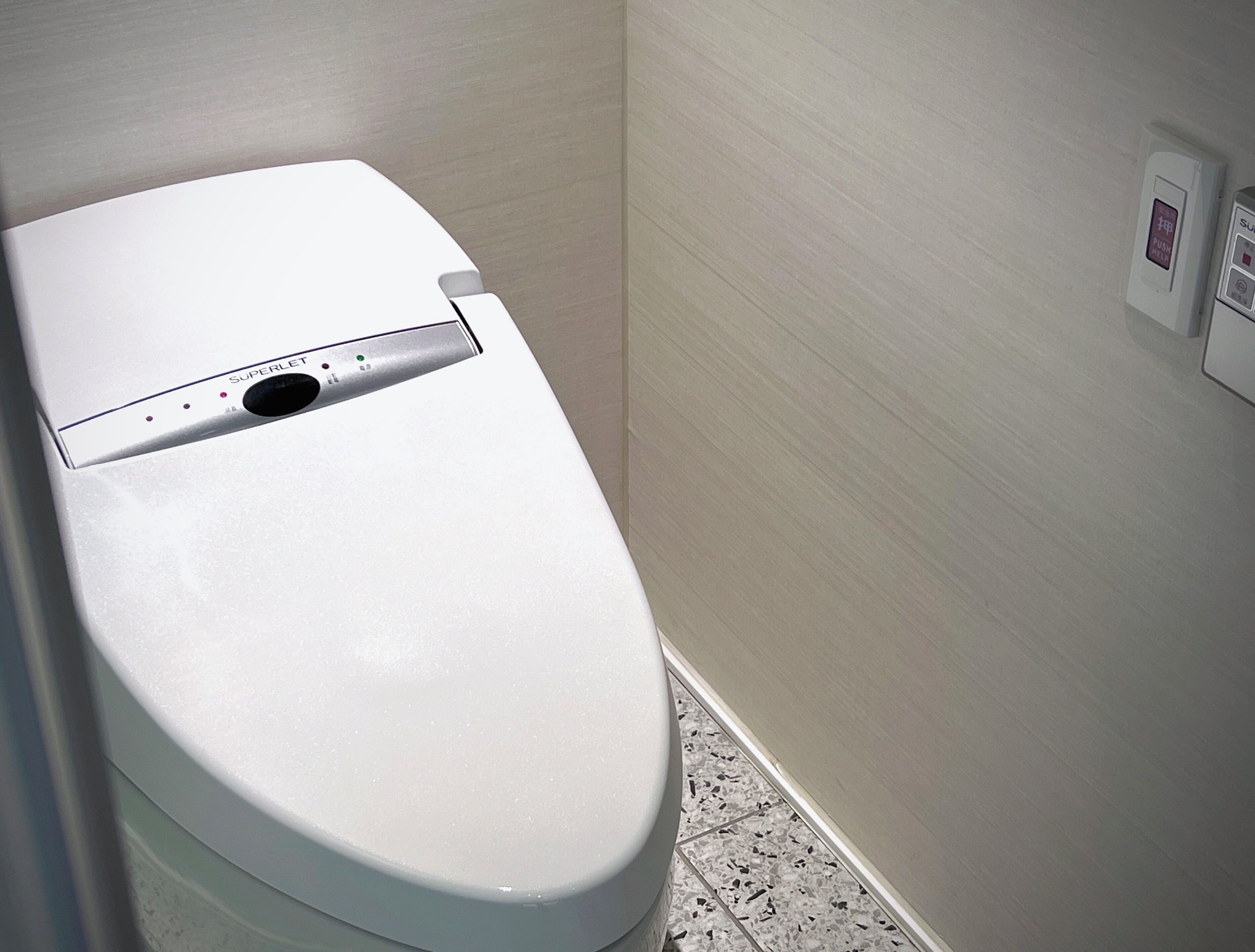 A white toilet with a control panel and a flush button.