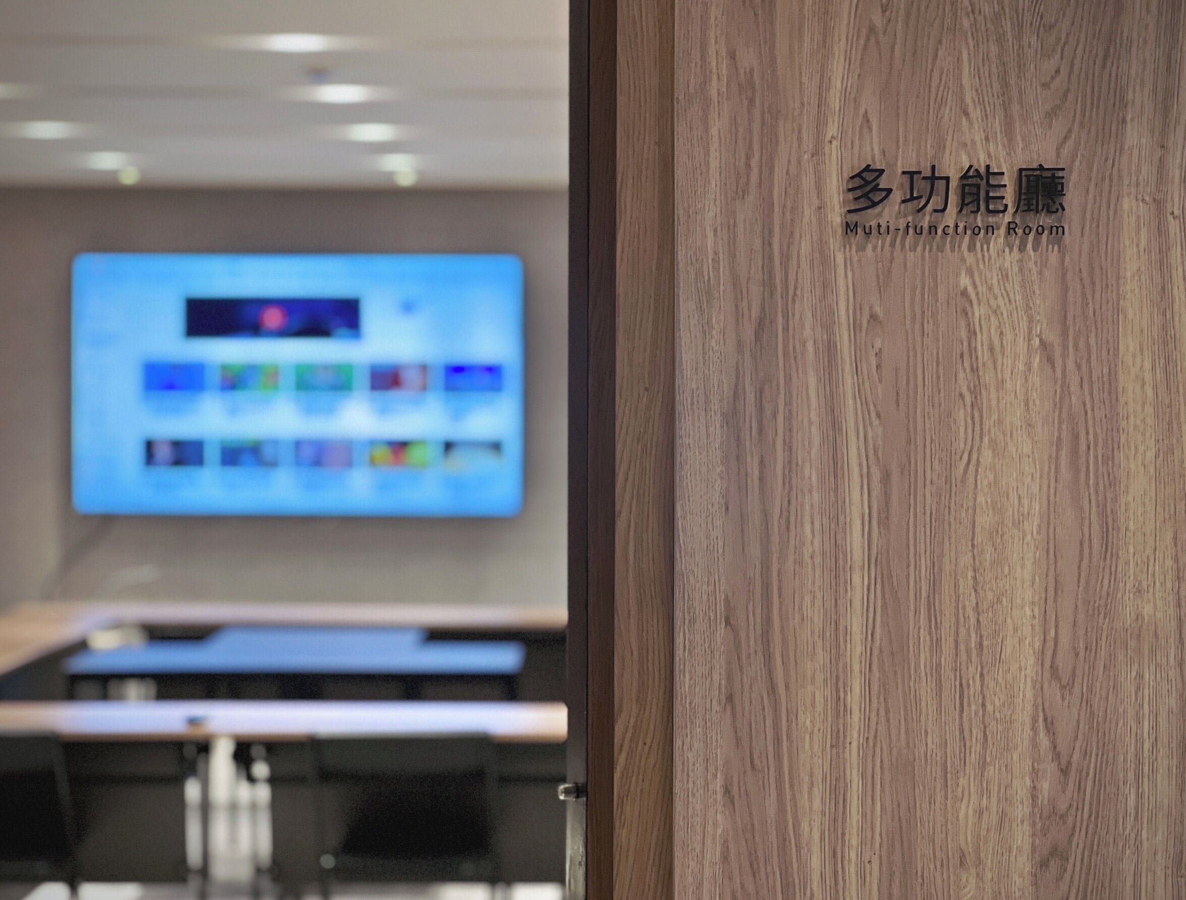 A room with a wooden door and a large screen displaying colorful icons.