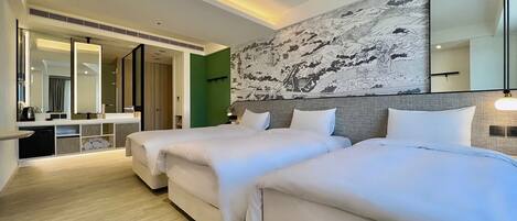 A hotel room with two beds, a large mirror, a wall with a detailed mural, and a small seating area with a table and chairs.