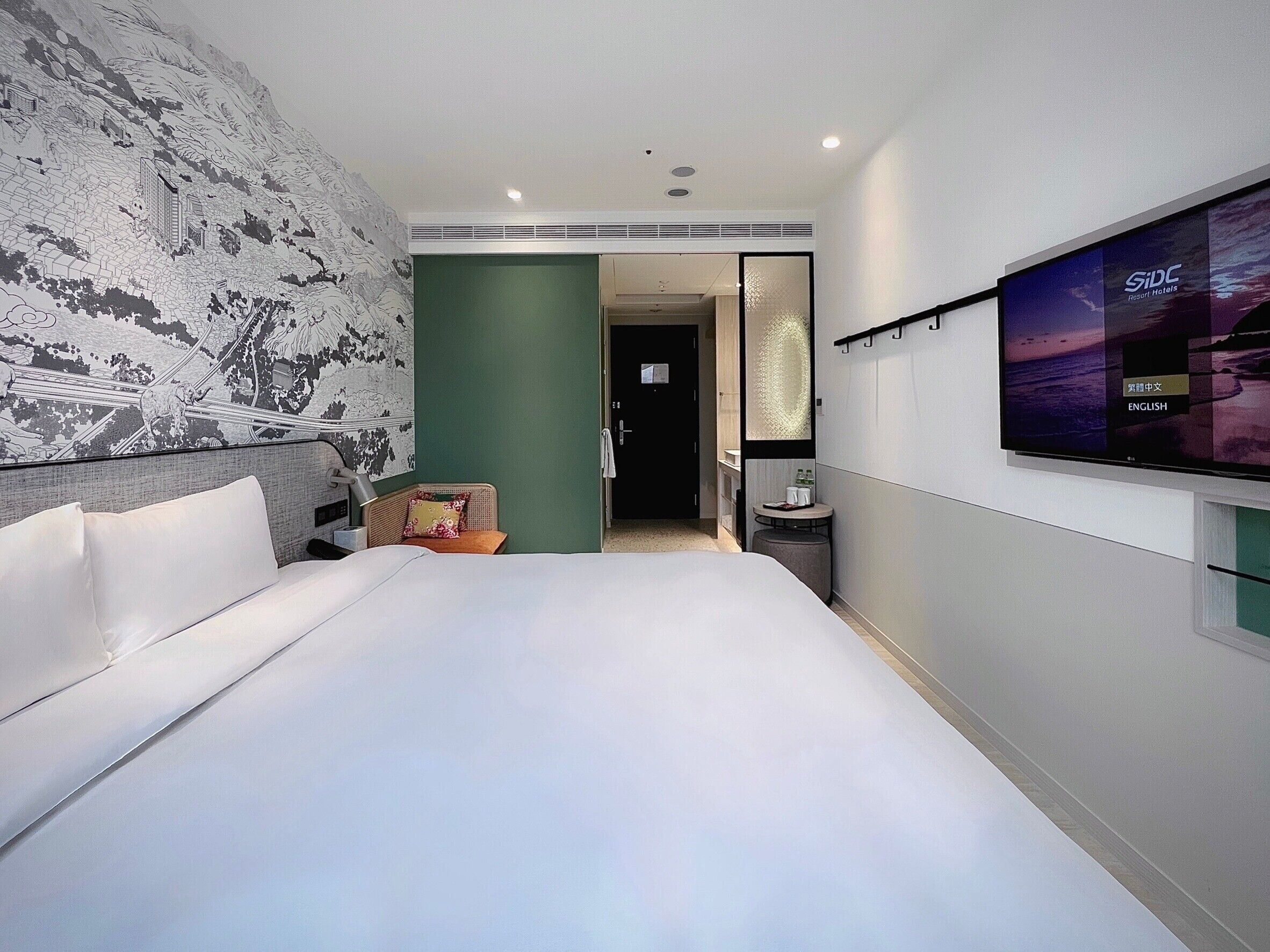 Een moderne hotelkamer met een groot bed, een zithoek, een televisie en uitzicht.