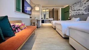 A hotel room with a sofa, two beds, a desk, and a large mirror. - Jiantan Boutech Hotel (Taipei)