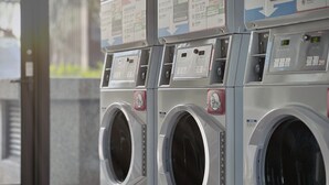 A row of industrial-style, stainless steel front-loading washing machines with digital displays and control panels. - Jiantan Boutech Hotel (Taipei)