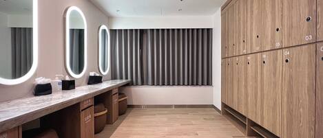Un baño moderno con tocador, espejos y muebles de madera.