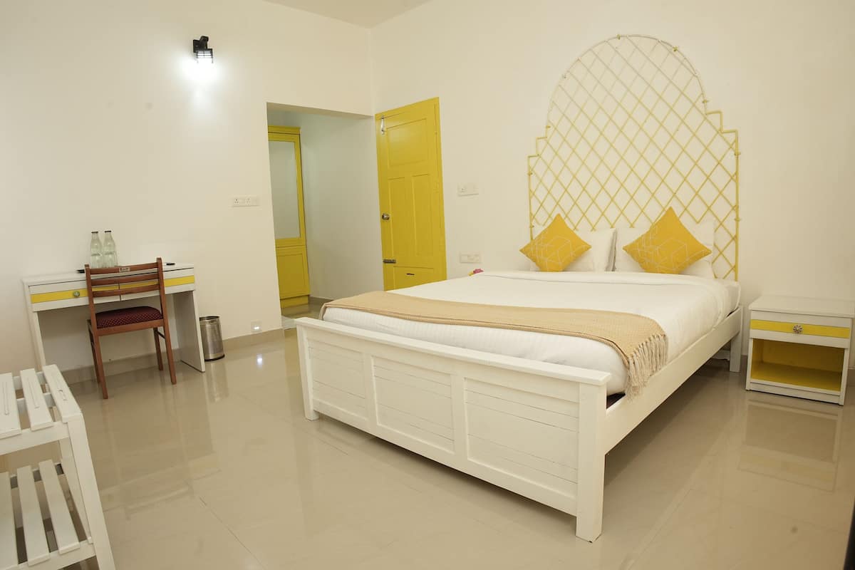 A bedroom with a bed, a desk, a chair, and a wardrobe.