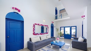 Una sala de estar moderna con una puerta azul, un sofá, una mesita de centro y un espejo grande.