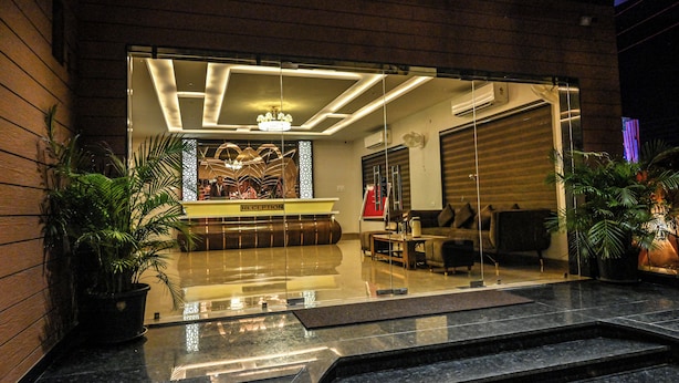 A reception area with a reception desk, seating, and a staircase leading to an upper floor. - M D Farms & Resorts (Mathura)