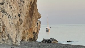 Un paisaje costero con un acantilado rocoso y mar tranquilo.