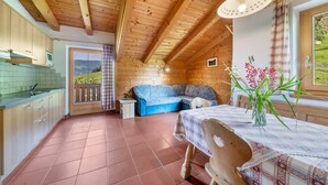 Un intérieur en bois comprenant une cuisine, un coin repas et un canapé.