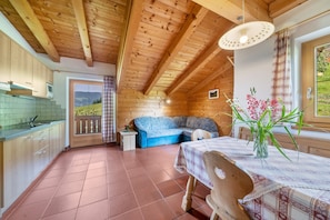A wooden interior with a kitchen, dining area, and a sofa.