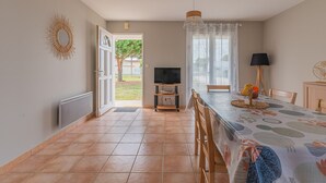 Un comedor con una mesa, sillas, un televisor y una lámpara.