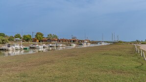 Un canal con barcos amarrados, rodeado de zonas verdes y edificios.