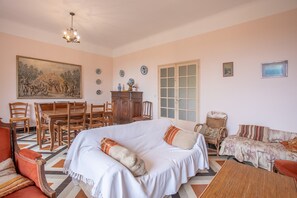 Une pièce comprenant un grand lit, une table à manger avec des chaises, un canapé et un fauteuil.