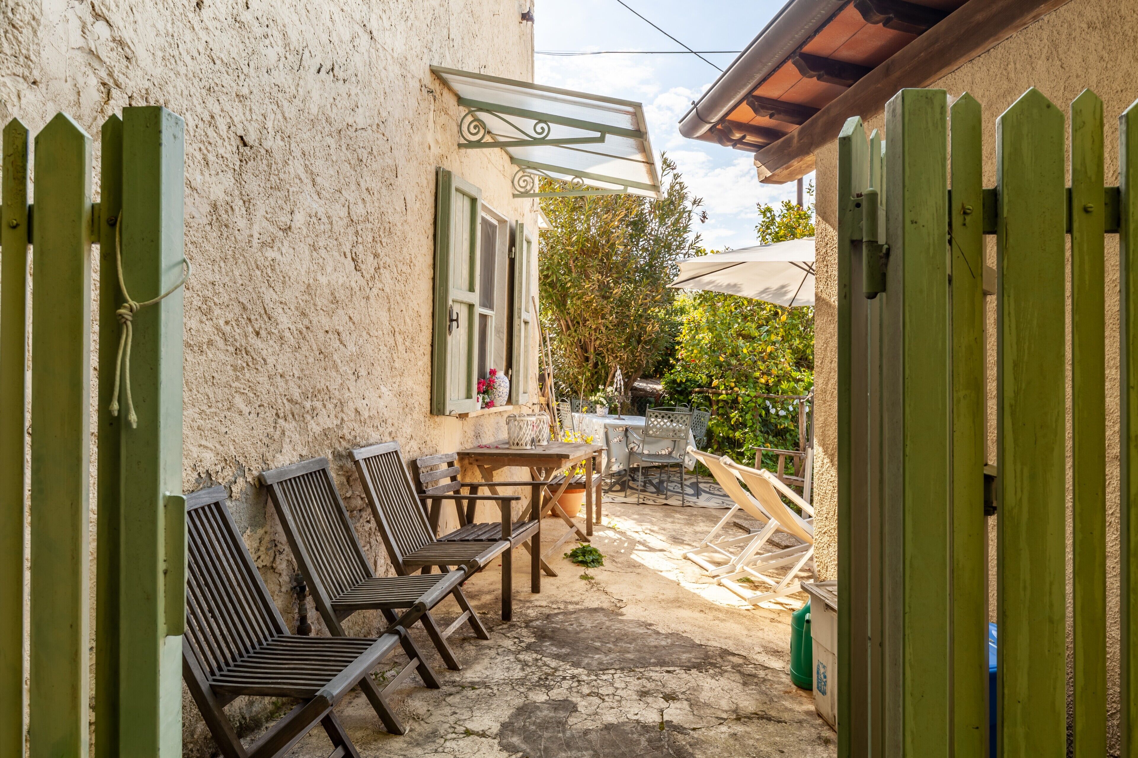 Eine Terrasse mit Gartenmöbeln, einem Tisch und einer Pergola.