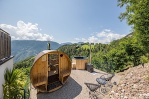 Une cabane en bois dotée d’un bain à remous et d’un espace extérieur aménagé, le tout niché au cœur d’un paysage montagneux.