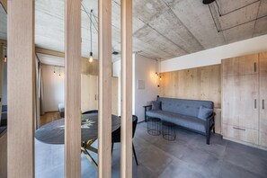 Un interno moderno con un tavolo da pranzo rotondo, un divano e pensili in legno.