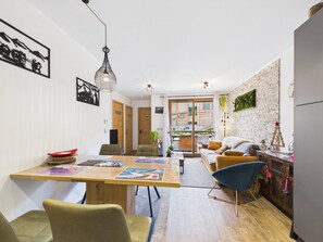 Eine moderne Küche mit Holztisch, Stühlen und einem Kühlschrank.