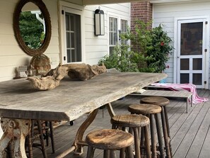 A rustic wooden table with stools, a large mirror, and a brick wall. - Cutchogue Farmhouse Estate with hot tub and gardens, walk to beach & vineyards (Cutchogue)