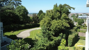 Un quartier résidentiel doté d’une allée sinueuse, d’une végétation luxuriante et offrant une vue sur la mer.