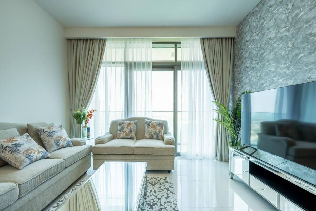 A modern living room with a sofa, a coffee table, and a TV.