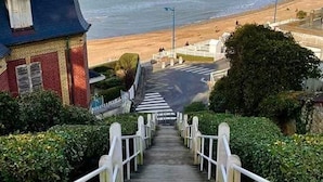 A staircase leading to a beach area with a view of the sea.