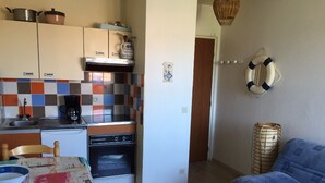 A compact kitchen with a dining table, a sofa, and a small living area.