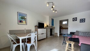 Un espacio habitable compacto con comedor, kitchenette y sofá.