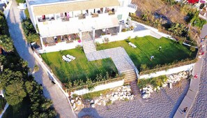 Un bâtiment moderne doté d’une cour intérieure, d’un espace extérieur aménagé avec des sièges et d’un espace piscine.
