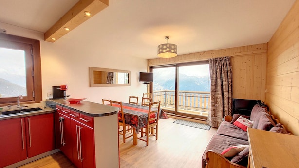 A modern kitchen with a dining area, a sofa, and a TV. - Bright 3-room apartment - La Rosière - Balcony, Parking - 6 pers (Montvalezan-La Rosière)