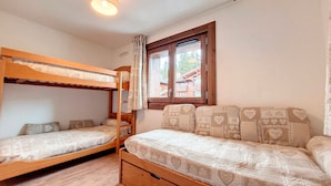 A room with bunk beds, a window with curtains, and a wooden floor. - Bright 3-room apartment - La Rosière - Balcony, Parking - 6 pers (Montvalezan-La Rosière)