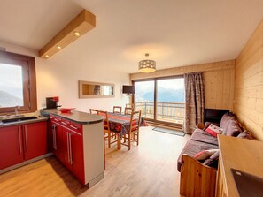 Una cocina moderna con comedor, sofá y televisor.