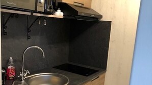 Eine Küche mit Spüle aus Edelstahl, einer Mikrowelle und einem eingebauten Backofen.