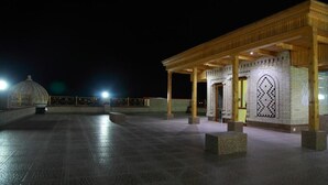 A covered outdoor area with a tiled floor and a wooden pavilion structure. - Hotel Sultan Boutique (Samarkand)