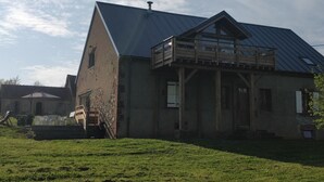 A large, rustic barn-style building with a metal roof and a wooden balcony.