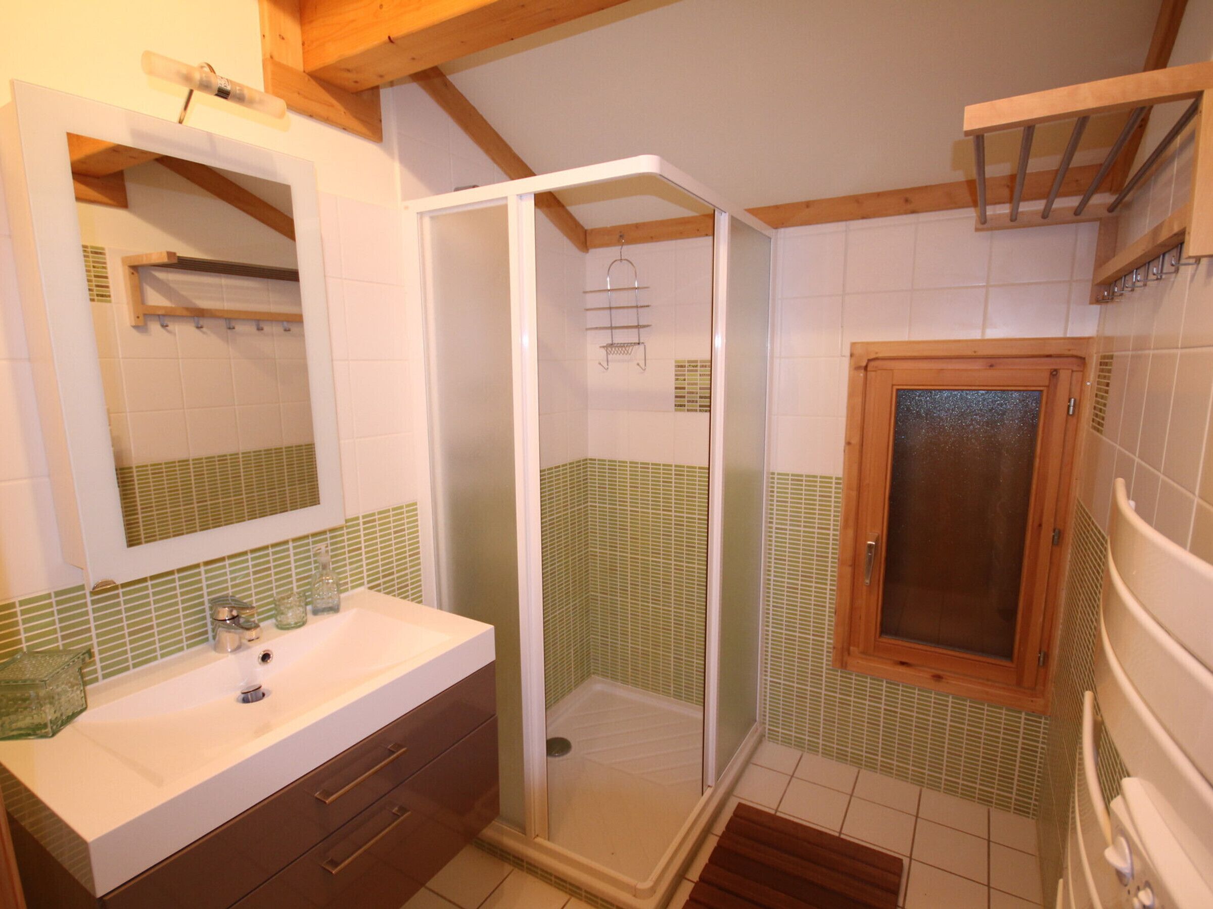 A bathroom with a shower, a sink, and a mirror.